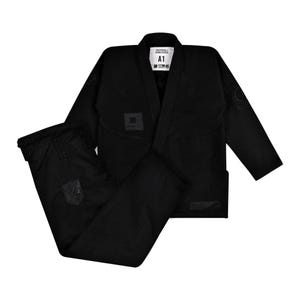 May include: A black jiu-jitsu gi set consisting of a long-sleeve jacket and matching pants. The jacket features a white inner neck label with the text A1 and Undefeated. Subtle black tonal branding patches are visible on the chest and pants.