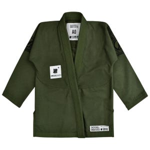 May include: An olive green jiu-jitsu gi jacket featuring a thick collar, long sleeves, and black circular logos on the shoulders. A white patch on the chest reads Undefeated, and a white label at the neck displays the size A0 and brand text.