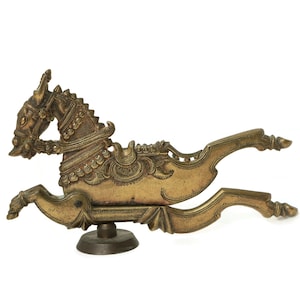 Pode incluir: Um quebra-nozes de metal dourado em forma de cavalo com detalhes intrincados. O cavalo está em uma pose de corrida com a cabeça virada para o lado. O quebra-nozes tem uma base e é feito de metal.