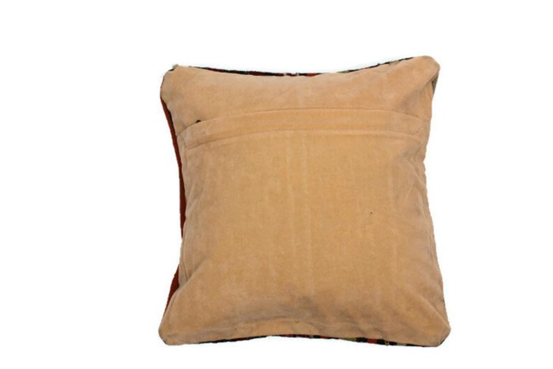 May include: A beige pillow with a red and black patterned back. The pillow is made of a soft, plush fabric.