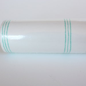 May include: A roll of white wallpaper with three thin green stripes running vertically down the roll.
