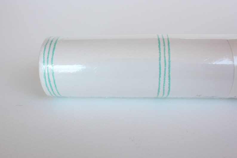 May include: A roll of white wallpaper with three thin green stripes running vertically down the roll.