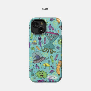 May include: A blue phone case with a glossy finish features a whimsical pattern of colorful aliens, stars, and other space-themed illustrations. The text "Christy + Madison" is printed on the case.