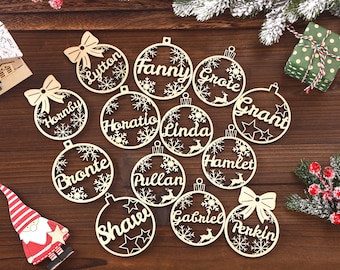 May include: Wooden Christmas ornament cutouts with names like Lytton, Fanny, and Grote. Each ornament is shaped like a Christmas ball with snowflake and star details. Some have bow accents.