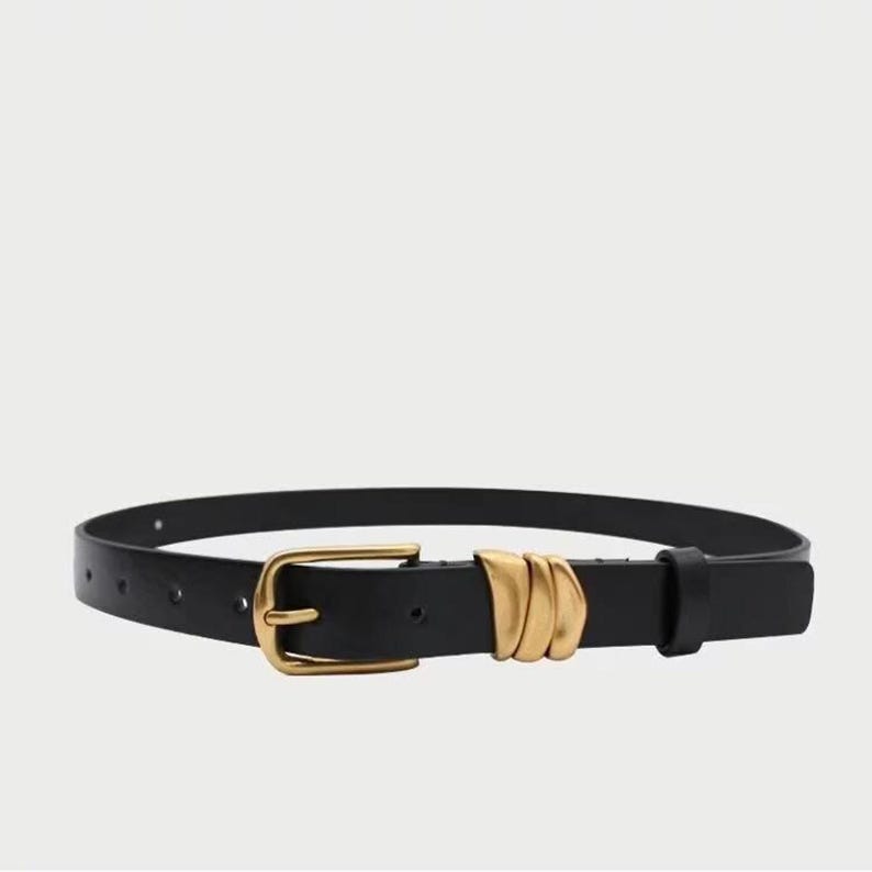 A black leather belt with a gold-tone buckle and three gold-tone decorative loops