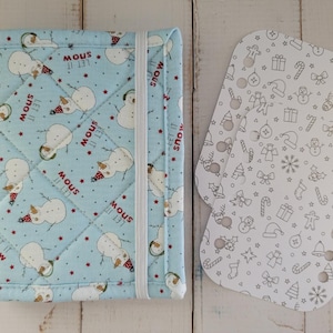 May include: A light blue quilted journal cover with a snowman pattern and the text "Let it snow". Includes a white elastic band closure. Two white, patterned inserts with Christmas-themed illustrations are also shown.