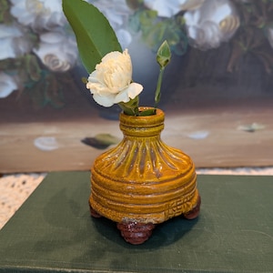 May include: A white ceramic mug with a black handle and the text "But First, Coffee" in a black, bold font. The mug is sitting on a wooden surface.