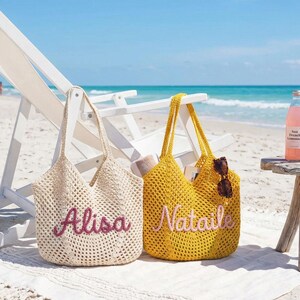 May include: Two crochet tote bags with open-knit patterns. The cream-colored bag features the name Alisa in dark pink script, while the yellow bag displays the name Nataile in light pink script. Both bags have two shoulder straps.