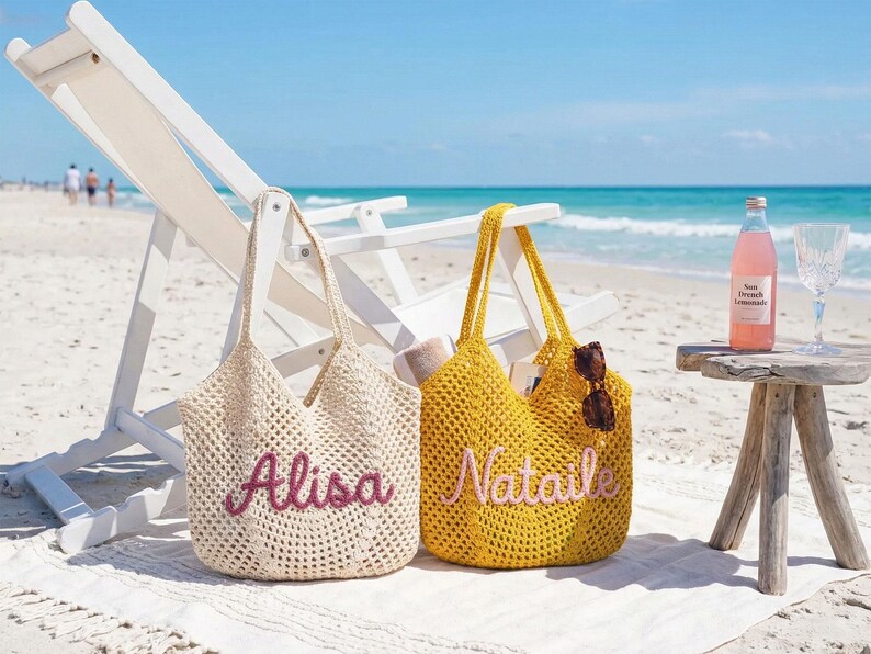 May include: Two crochet tote bags with open-knit patterns. The cream-colored bag features the name Alisa in dark pink script, while the yellow bag displays the name Nataile in light pink script. Both bags have two shoulder straps.