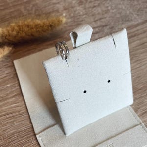May include: Two silver rings displayed on a white velvet ring box with the text "STILECHT COLOGNE" on the bottom.
