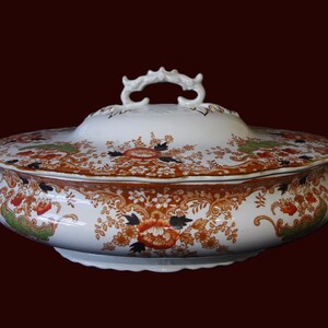 Antique W. Adams Crown Derby Imari Style lidded serving dish with white base with an orange, green, and black floral pattern.