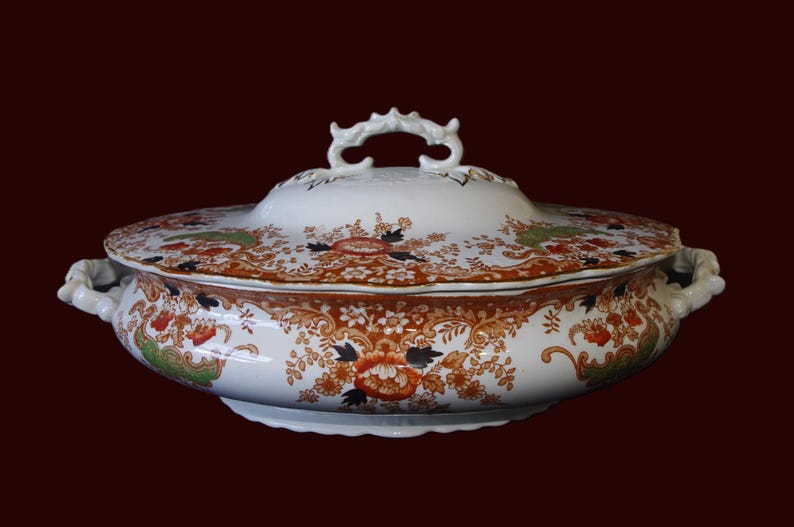Antique W. Adams Crown Derby Imari Style lidded serving dish with white base with an orange, green, and black floral pattern.