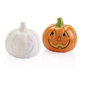 May include: Two ceramic pumpkins, one painted white and one orange, with a carved jack-o'-lantern face.