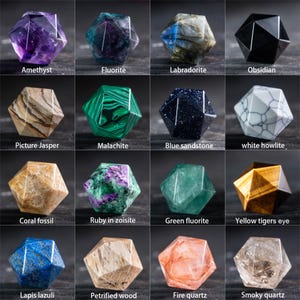 May include: A collection of sixteen faceted gemstone crystals, each with a unique color and pattern. The gemstones include amethyst, fluorite, labradorite, obsidian, picture jasper, malachite, blue sandstone, white howlite, coral fossil, ruby in zoisite, green fluorite, yellow tigers eye, lapis lazuli, petrified wood, fire quartz, and smoky quartz.