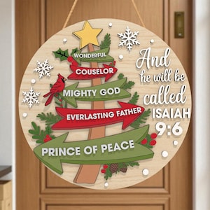 May include: A circular wooden Christmas sign with a tree design. The sign features a red cardinal, snowflakes, and the text "Wonderful Counselor, Mighty God, Everlasting Father, Prince of Peace." The sign also includes the text "And he will be called Isaiah 9:6."
