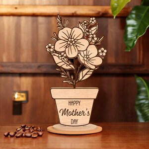May include: Wooden cutout of a potted plant with flowers and the text "Happy Mother's Day".