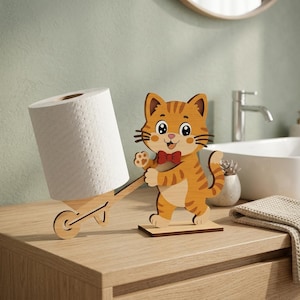 May include: A novelty toilet roll holder featuring a cartoon cat. The orange and brown wooden cat figure is pushing a wheelbarrow holding a white toilet roll. The cat wears a red bow tie. The holder is on a wooden surface.
