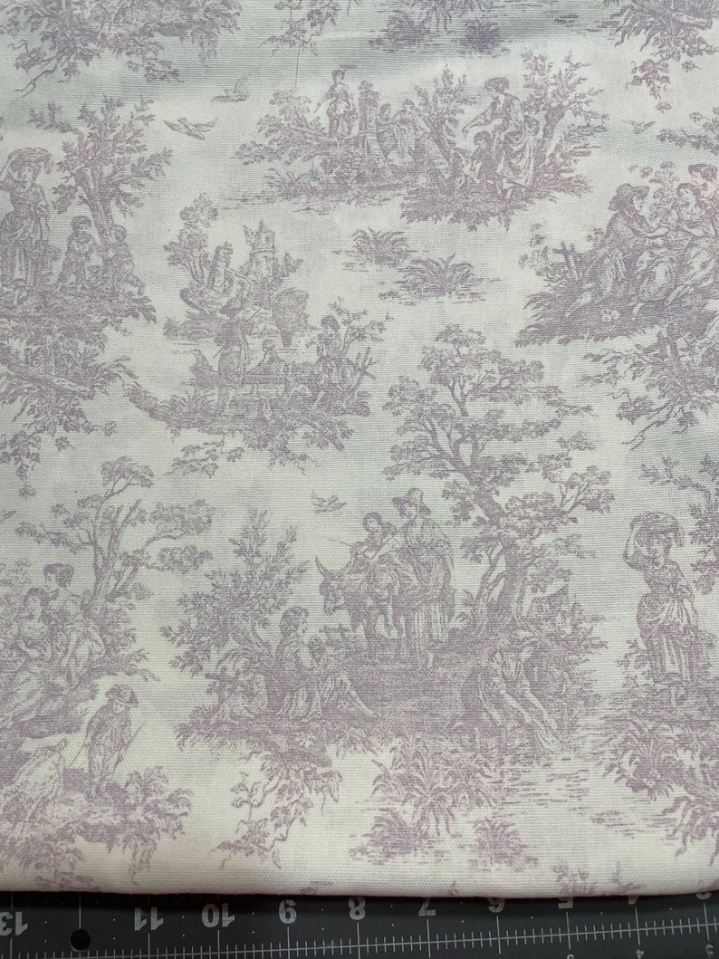 May include: Off-white fabric with a repeating toile pattern in a muted purple hue. The design depicts scenes of people in a pastoral setting, including figures, trees, and architectural elements. The fabric is likely cotton or a similar material.