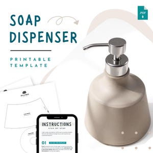 May include: A cream-coloured soap dispenser with a silver pump, alongside a smartphone showing instructions and printable templates. The image text says "SOAP DISPENSER PRINTABLE TEMPLATE" and "INSTRUCTIONS STEP BY STEP".