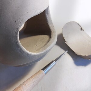 Cutting the oval window of a ceramic oil burner, wax melter slab template in progress