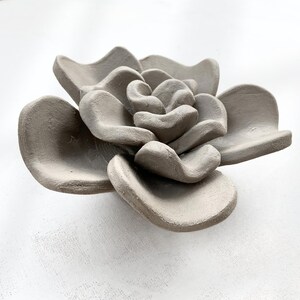 Single handmade clay flower shaped from succulent pottery template, showing organic wabi-sabi form for handmade ceramics or air dry clay decor.