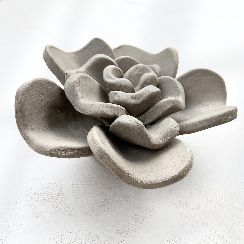 Single handmade clay flower shaped from succulent pottery template, showing organic wabi-sabi form for handmade ceramics or air dry clay decor.