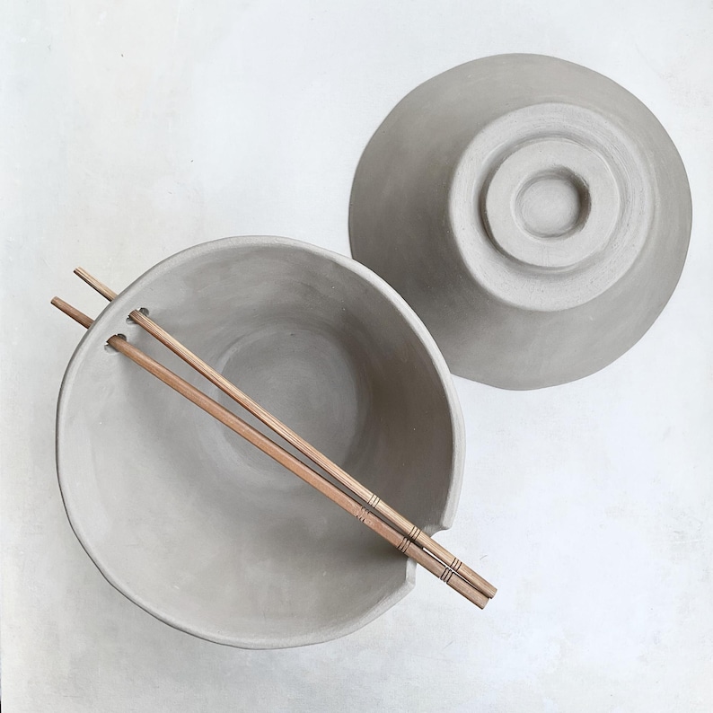 Functional set with two pottery bowls and chopsticks, top-down angle, perfect for sharing noodle or soup meals.