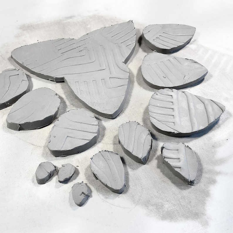 Cut clay petals and leaves made with printable clay template for flowers, ready to assemble into succulent pottery using simple pottery tools.