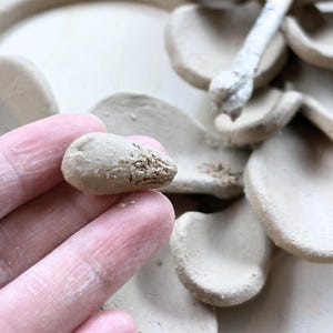 Close-up of forming a single clay leaf for a handmade ceramics wreath, showing air dry clay texture and careful handbuilding process.