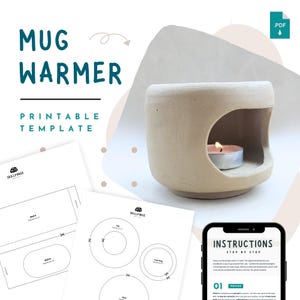 Pode incluir: Um aquecedor de caneca de cerâmica bege com uma abertura circular, iluminado por uma pequena vela. A imagem inclui um modelo imprimível e instruções em um smartphone, com o texto "Mug Warmer Printable Template".