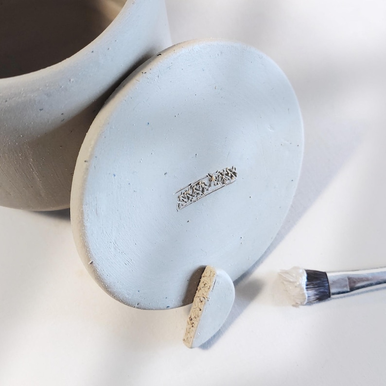 Attaching the knob to the storage jar | adding detail to slab-built pottery | clay container base
