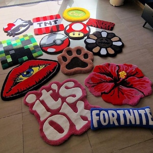 May include: A collection of colorful, decorative rugs in various shapes and designs. Includes a red lip design, a Minecraft block, a paw print, a mushroom, and a rug with the text "it's OK".