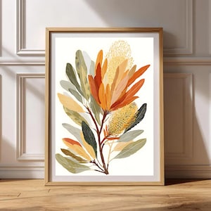 Puede incluir: Una impresión botánica enmarcada que presenta una ilustración estilizada de una planta con flores. La obra de arte muestra una vibrante gama de colores, incluyendo naranja, amarillo, verde y marrón, con un marco de madera clara. La impresión se exhibe sobre un fondo blanco.