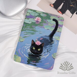 Può includere: Stampa artistica rettangolare raffigurante un gatto nero che nuota in uno stagno con ninfee e fiori rosa. Il gatto indossa una corona di fiori rosa. L'opera d'arte è in stile pittorico con tonalità blu, verdi e viola. La stampa ha il testo "Russha Gifts" in basso.