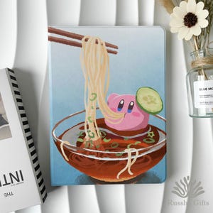 Może przedstawiać: Ilustracja różowej postaci z kreskówki w misce z ramenem, z pałeczkami trzymającymi makaron. Miska ma plasterek ogórka i zieloną dekorację. Tło jest jasnoniebieskie.