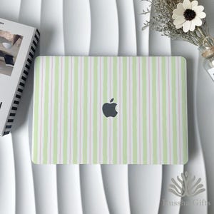 Op de afbeelding: Een laptopsticker met een verticaal streeppatroon in afwisselende tinten lichtgroen, zachtroze en wit. Het ontwerp bedekt het rechthoekige oppervlak van de laptop, met een gecentreerd donkergrijs Apple-logo op de buitenkant van het deksel.