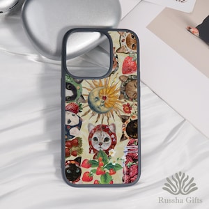 May include: A phone case with a whimsical design featuring cats, strawberries, and a sun-moon illustration. The case has a dark gray border and a cream-colored background. The design includes a jar of strawberries and the text "Russha Gifts".