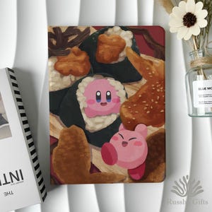 Könnte beinhalten: Ein pink-weiß illustrierter Notizbuchumschlag mit einem Sushi- und Kirby-Design. Der Umschlag hat einen roten Hintergrund mit verschiedenen Sushi-Stücken und zwei Kirby-Charakteren. Das Notizbuch ist ein einzigartiges und farbenfrohes Accessoire.