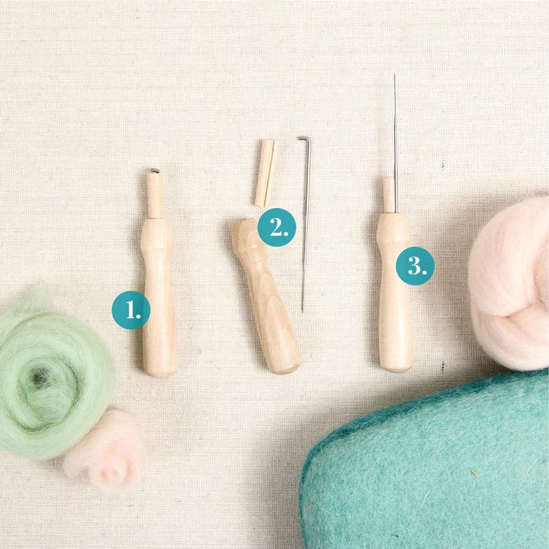 May include: Three wooden needle felting tools with a green and pink wool roving, a teal felting pad, and a white background. The tools are labeled 1, 2, and 3.