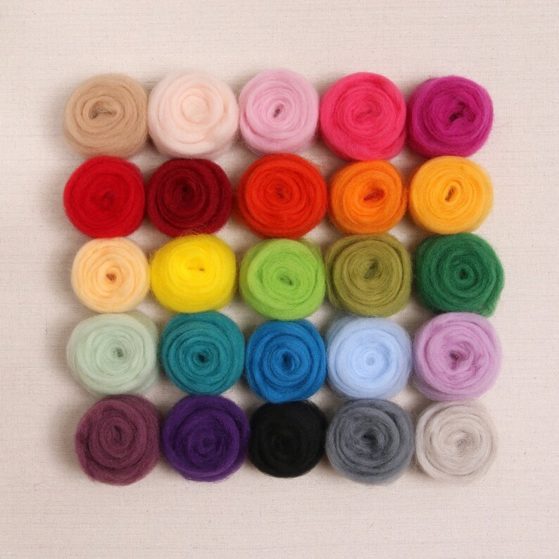 May include: A set of 24 colorful wool roving balls, arranged in a grid pattern. The balls are various shades of red, orange, yellow, green, blue, purple, pink, and brown.