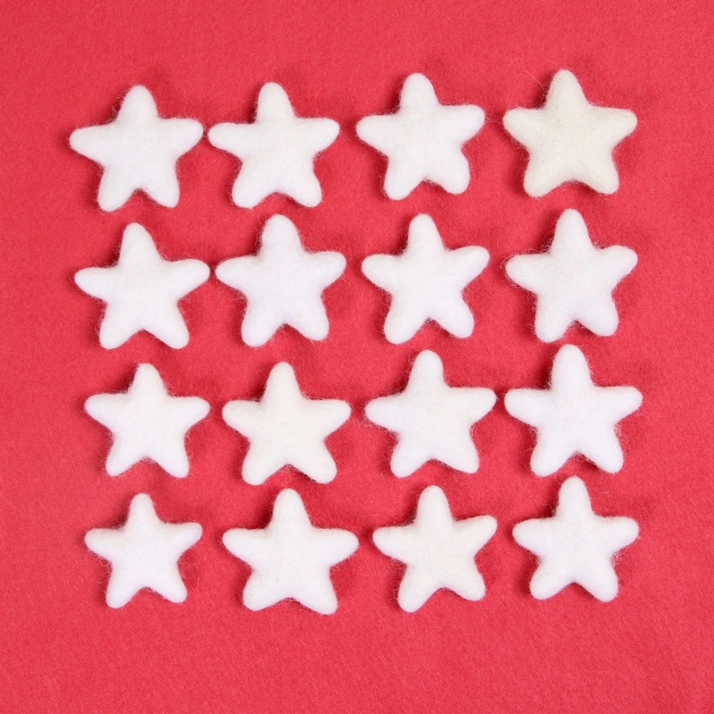 May include: A red felt background with 15 white felt stars arranged in a grid pattern.