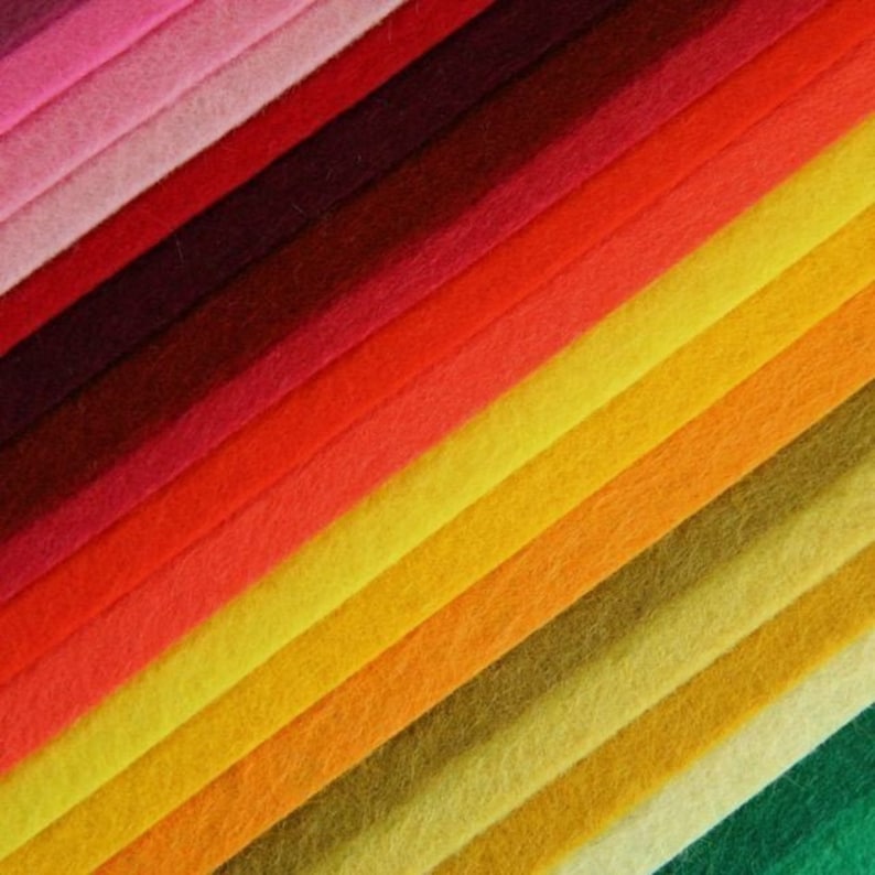 May include: A collection of felt fabric strips in various shades of red, orange, yellow, and green. The strips are arranged in a diagonal pattern, creating a gradient effect.