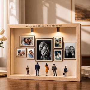 Może przedstawiać: Drewniane pudełko z napisem "Anna and Mom's Art Museum" nad kolekcją oprawionych zdjęć. Miniaturowe figurki stoją pod zdjęciami. Zdjęcia są w różnych rozmiarach i zawierają obrazy czarno-białe i kolorowe.