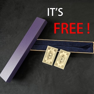 May include: A purple rectangular box with a matching wand inside, along with two small tags. The box is open, revealing a dark blue interior. The text "IT'S FREE!" is displayed in white and red.