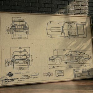 May include: A framed technical blueprint print on tan paper featuring the Datsun 240 Z 1969 Typ L24. The illustration displays the car from front, top, and side views with detailed dimension lines, technical annotations, and the Datsun logo.