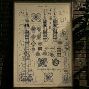 Peut inclure: Un plan vintage encadré d'une fusée, avec des dessins techniques détaillés et le texte "Model - 18/231". Le plan est en beige et bleu, avec des schémas et des schémas complexes. L'œuvre est exposée contre un mur de briques sombres.