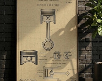 May include: A framed patent print titled Improved Engine Piston, No. 596,977, featuring technical line drawings of a piston and connecting rod assembly on a tan grid background. The document includes labels for parts and the signature Robert B. Adams.