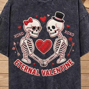 May include: Dark grey t-shirt with a skeleton couple holding hands, a red heart between them, and the text "Eternal Valentine" and "XOXO". The design includes a bow, top hat, and arrows. The bottom of the image says "PNG SUBLIMATION FILE".