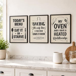 May include: Three rectangular wall art prints in black frames with cream backgrounds and black text. The first reads: TODAY'S MENU EAT IT OR STARVE. The second: BAKING The only time I FOLLOW DIRECTIONS. The third: MY OVEN AND I HAVE A HEATED Relationship.