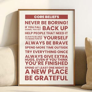 May include: A framed print with the words "Core Beliefs" at the top, followed by inspirational phrases in a bold, red font. The print is displayed on a light-colored sofa, with a neutral background.